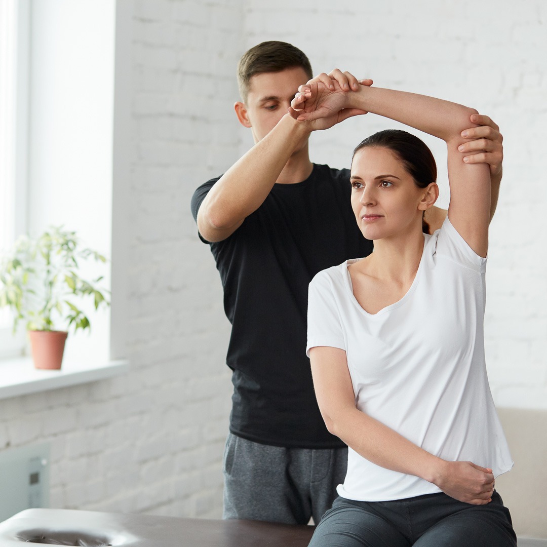 Patientin macht körperliche Übungen mit Physiotherapeut –YURII MASLAK © AdobeStock
